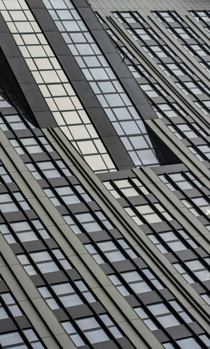 Glass high-rise facade with diagonal metal lines